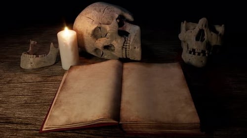 Offenes antikes Buch mit menschlichen Schädeln und glühendem Kerzenlicht
