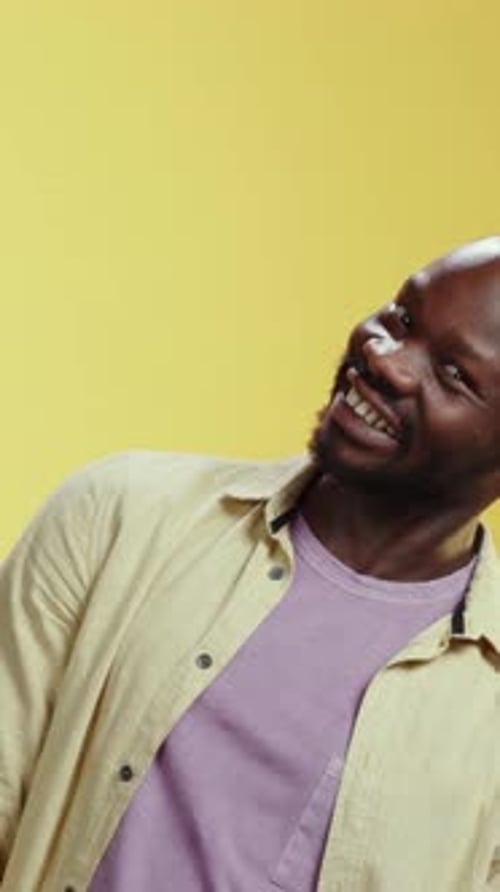 Man Making Expressions on Yellow Background Portrait