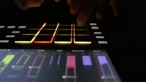 Fingers Using Illuminated Beat Machine in Dark Studio