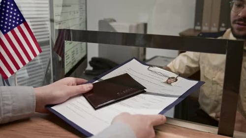 Handing Over Passport and Paperwork at Desk