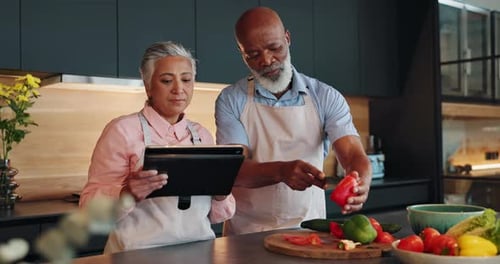Mature Couple Cooking Vegetables in Modern Kitchen