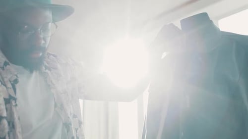 Man Measuring Garment on Mannequin with Measuring Tape