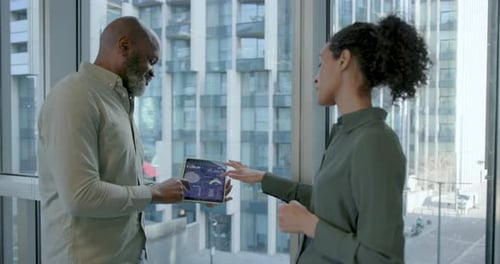 Two Business People Discussing Presentation on Digital tablet, Working and Meeting in Office