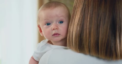 Adorable Baby Held Comfortably Indoors in Natural Light