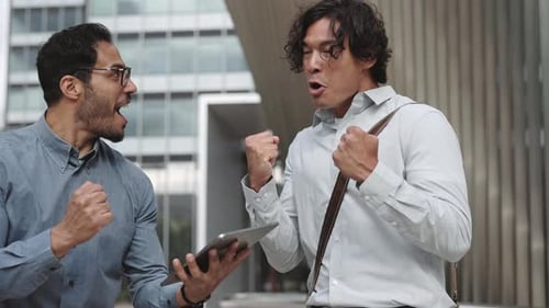 Young Adults Celebrate Business Success with Tablet