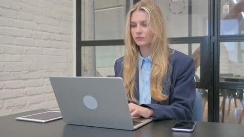 Blonde Businesswoman with Migraine Working in Office
