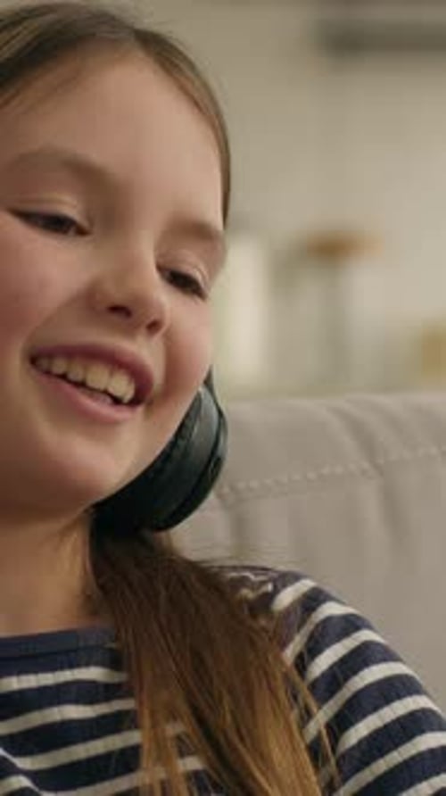 Girl with Headphones Listening to Music Indoors