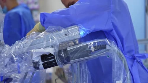 Female first assistant standing at the operative field at the robotic arms. Medic takes a wire