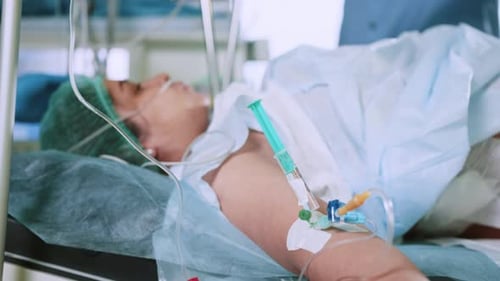 Medical Staff Attending to Patient in Hospital Bed