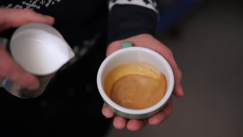 Pouring Milk into Coffee Cup in Close-Up