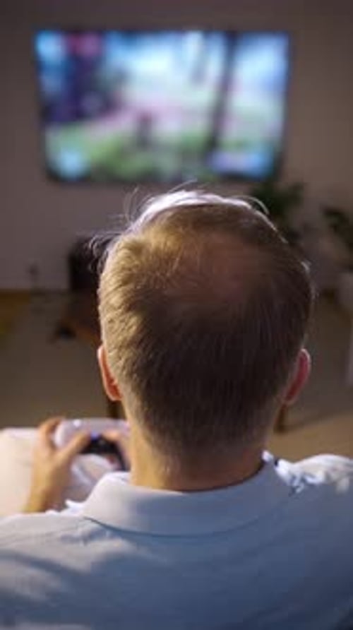 Adult Playing Video Games in Dark Home