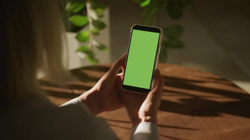 Unrecognizable Woman Holding Smartphone with Green Screen