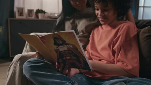 Child and Adult Reading a Comic Book Together