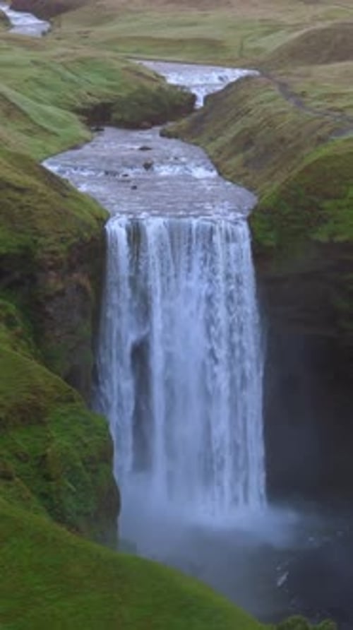 Iceland Waterfall Flows Over Green Cliffside