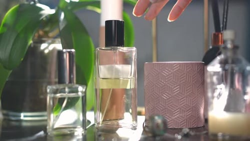 Parfums en gros plan sur la table avec une fine main féminine choisissant une eau de Cologne, laissant au Ralenti