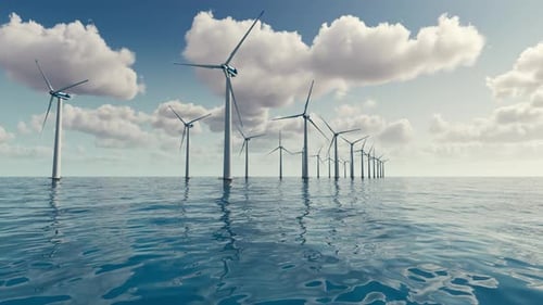 Large wind turbines generating electricity on the sea of a beautiful sunset and clouds.
