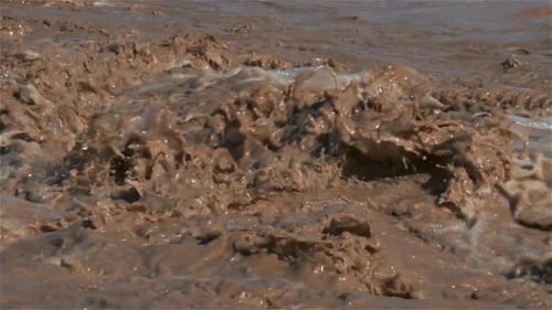 Slow Motion of Wild Water Splashing in Muddy River Rapids Global Warming Background