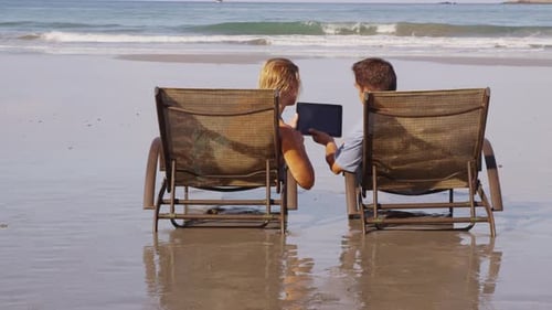 Couple Using Digital Tablet at Beach. on Red Epic for High