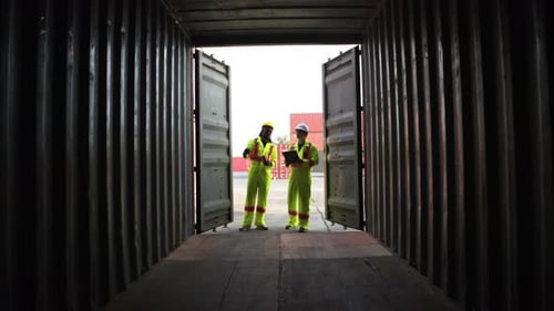 Workers Stand at Shipping Container Inspecting Inventory