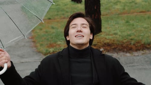 Smiling Man with Umbrella Enjoys the Rain