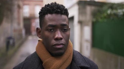 Contemplative black African male walking in city back alley