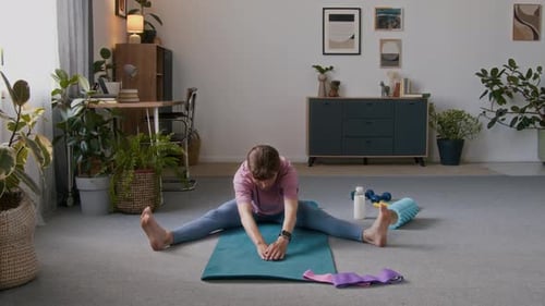 Woman Stretching on Yoga Mat Indoors
