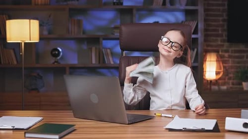 Little Girl Waving Dollars in Front of Face in Office