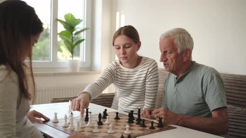Grandfather Playing Chess With Granddaughters