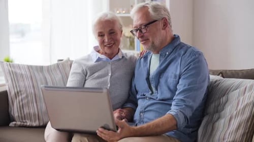 Senior Couple Video Chatting on Laptop in Living Room