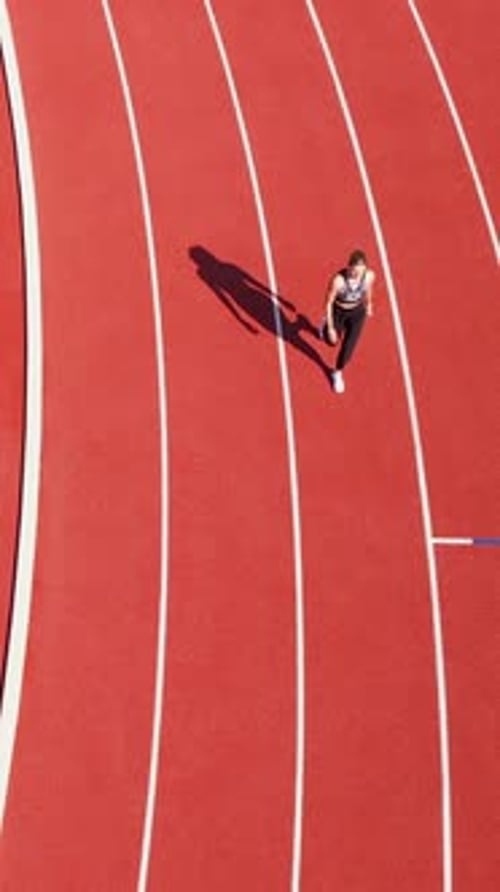 Overhead View: Woman Stands on Running Track