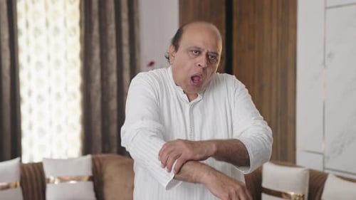 Man Rubbing Arm in Home Environment