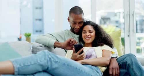 Happy Couple Relaxing and Using Smartphone at Home