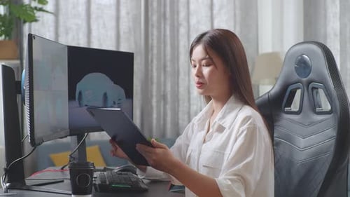 Side View Of Asian Female Automotive Designer Comparing The 3D Model Of Ev Car On The Computer