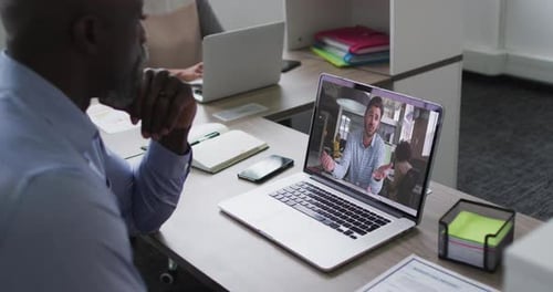 Man Attends Video Conference on Laptop in Office