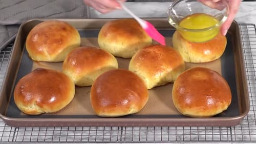 Zeitraffer Schritt für Schritt frisch gebackene Brioche-Brötchen auf einem Backblech mit einer Silikonmatte