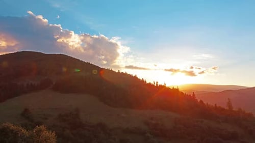 Golden Sunset Light Over Rolling Mountain Hills Covered in Pine Trees