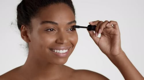 Woman Applying Mascara to Eyelashes in Close Up
