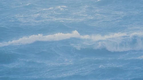 Calm Seagull Flying Over Rough Stormy Choppy Breaking Blue Sea Waves in Slow Motion