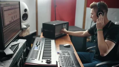 Young sound engineer working and equalizing audio in the studio
