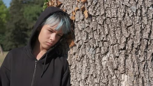 Fille aux souvenirs douloureux près d'un arbre