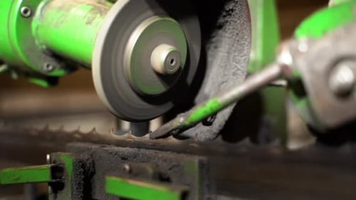 Automatic band saw blade sharpening with industrial machinery in closeup