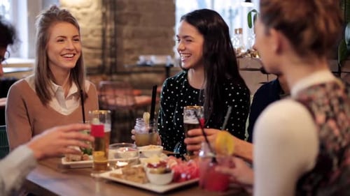 Friends Enjoying Drinks and Conversation at Cafe