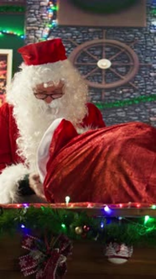 Vertical Video White Bearded Old Man in Costume Tying His Sack Full of Gifts