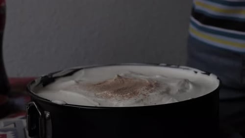 Sprinkling Chocolate on Cake While Home Baking