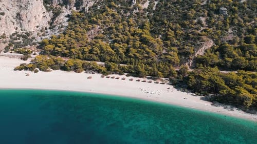 A paradise beach with resort next to a mountain and blue water sea - Turkey