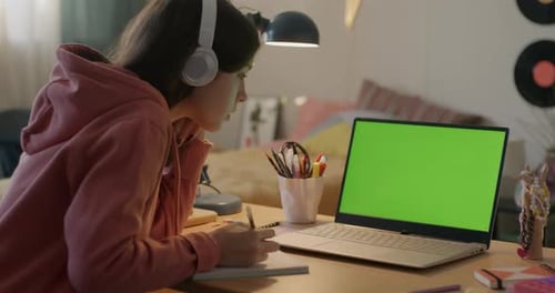 Teenager Studying in Internet School Looking at Chroma Key Green Screen Laptop Talking and Writing