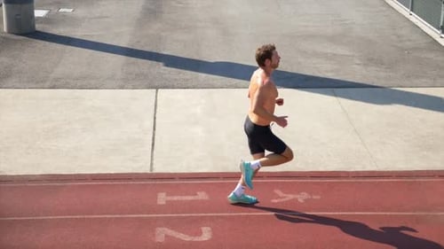 Athletic Man Running on Outdoor Track on Sunny Day