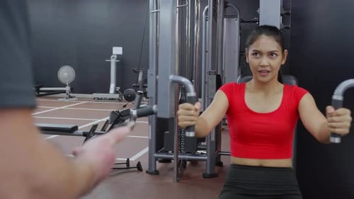 Woman Working out on Chest Press with Trainer