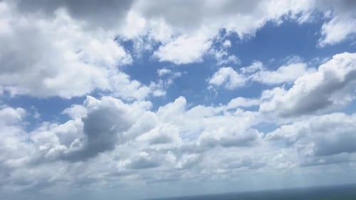 View From Window on Plane of Blue Sky With Clouds Background. Travel By Air On Airplane.