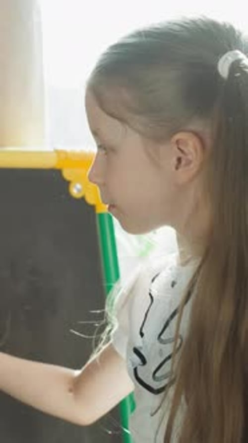 Schoolgirl Writes Mathematical Problems on Blackboard